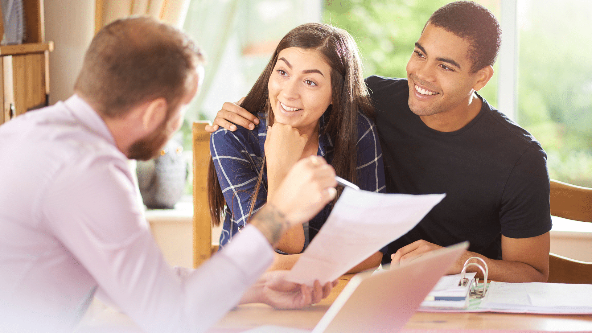 Couple discussing documents with advisor.