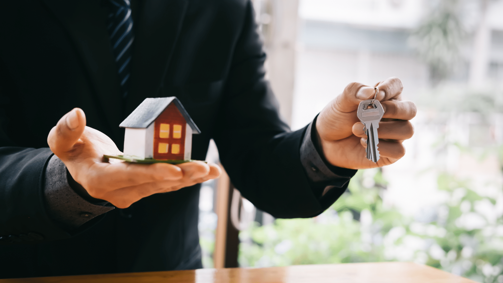 Man holding house model and keys